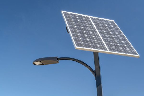street lamp with a solar panel against blue sky